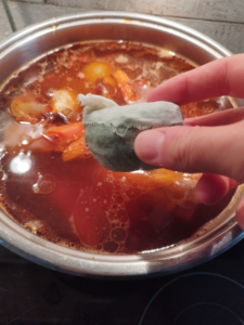 Photo is showing how vegetables and bouquet garni is added.